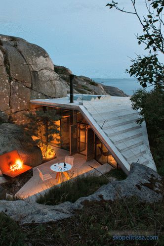 Maison aux murs transparents sur des rivages rocheux ensoleillés à Sandefjord, Norvège